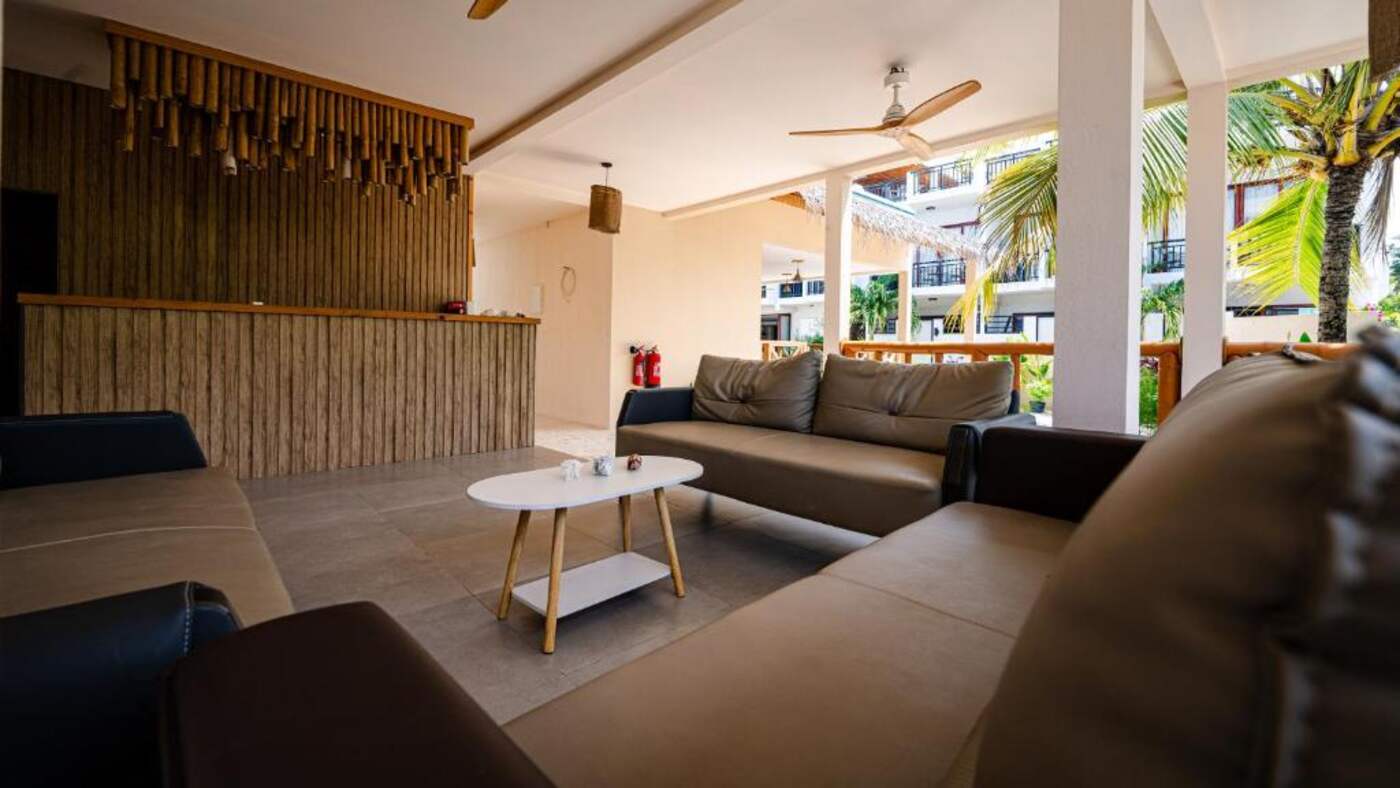 Open air lounge with sofas and a wooden reception desk